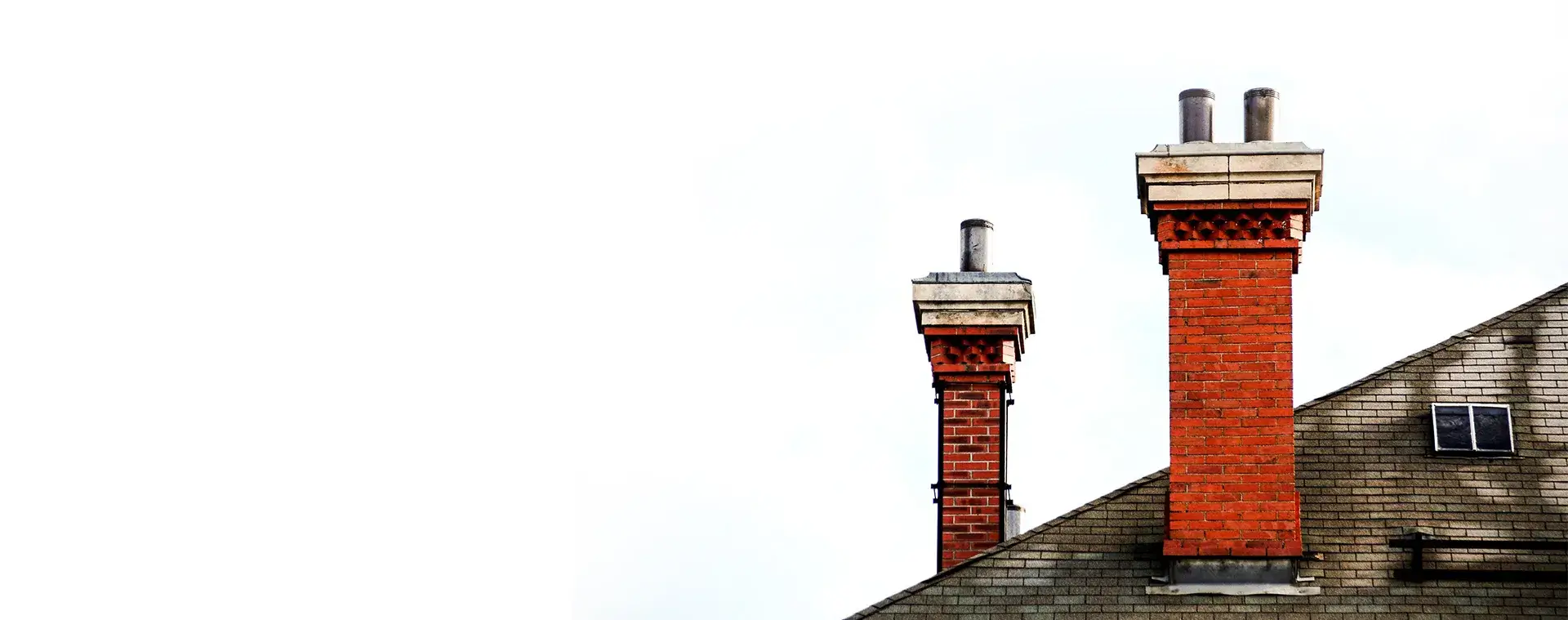 A brick chimney with a metal cap on top of it.